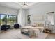 Bright main bedroom with a tray ceiling, large windows, and a cozy seating area at 16914 Vinci Way, Bella Collina, FL 34756