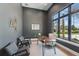 Modern office space with a large window, allowing for lots of natural light and views of the exterior landscaping at 16914 Vinci Way, Bella Collina, FL 34756