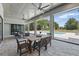 Covered outdoor living space with dining table and sitting area overlooking the sparkling pool at 16914 Vinci Way, Bella Collina, FL 34756