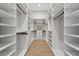 Spacious walk-in closet with custom shelving and drawers for optimal organization and storage at 16914 Vinci Way, Bella Collina, FL 34756