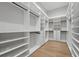 Large, custom walk-in closet with open shelving, drawers, and rods for ample storage at 16914 Vinci Way, Bella Collina, FL 34756