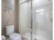 This pristine bathroom has a toilet and glass enclosed shower with white tiles at 2150 White Dahlia Dr, Apopka, FL 32712