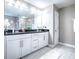 Bathroom with a double vanity, granite countertop, white cabinets, modern lighting and an oversized mirror at 2150 White Dahlia Dr, Apopka, FL 32712