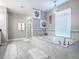 Bright bathroom features a soaking tub, a chandelier, tiled floors, and a separate glass door shower at 2150 White Dahlia Dr, Apopka, FL 32712
