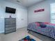 This bedroom has a Spiderman themed comforter, a dresser, and a wall-mounted television for optimal entertainment at 2150 White Dahlia Dr, Apopka, FL 32712