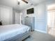 Bright bedroom with a ceiling fan, a television, a gray dresser, and an en-suite bathroom at 2150 White Dahlia Dr, Apopka, FL 32712