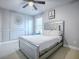 Bedroom with an elegant bed, framed wall art, a ceiling fan, a nightstand, and a window at 2150 White Dahlia Dr, Apopka, FL 32712