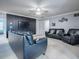 Cozy bonus room with a dark accent wall, black leather seating, a ceiling fan, and a wall-mounted TV, perfect for movie nights at 2150 White Dahlia Dr, Apopka, FL 32712