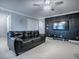 Bonus room featuring a black leather sofa, accent wall, ceiling fan, and wall-mounted TV, ideal for Gathering entertainment at 2150 White Dahlia Dr, Apopka, FL 32712