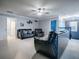 Comfortable bonus room with plush carpeting, black leather seating, and a ceiling fan, offering a versatile space for relaxation at 2150 White Dahlia Dr, Apopka, FL 32712