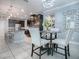 Breakfast nook with glass table, white chairs, and modern light fixture at 2150 White Dahlia Dr, Apopka, FL 32712