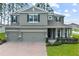 Two-story house with gray siding, three-car garage, and landscaped lawn at 2150 White Dahlia Dr, Apopka, FL 32712
