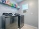 This laundry room boasts new front loading washer and dryer, and ample storage with shelving at 2150 White Dahlia Dr, Apopka, FL 32712
