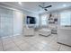Bright living room with large windows, tile floors, comfortable seating, and a ceiling fan, perfect for relaxation and gatherings at 2150 White Dahlia Dr, Apopka, FL 32712