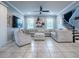 Expansive living room with neutral tones, tile flooring, large sectional, and a staircase, creating an inviting and open atmosphere at 2150 White Dahlia Dr, Apopka, FL 32712