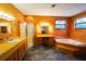 Bathroom with a shower, bathtub, and wood-paneled walls at 3140 Se 23Rd Pl, Sumterville, FL 33585