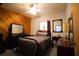 Cozy bedroom with wood-paneled walls and a full bed at 3140 Se 23Rd Pl, Sumterville, FL 33585