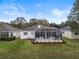 House exterior with a large screened patio and landscaped yard at 4351 Hammersmith Dr, Clermont, FL 34711