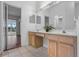 Bathroom boasts double sinks, light wood cabinets, and a view into the bedroom at 4351 Hammersmith Dr, Clermont, FL 34711