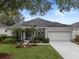 Single-story house with landscaped yard and two-car garage at 4351 Hammersmith Dr, Clermont, FL 34711