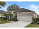 House exterior showcasing a large garage and lush landscaping at 4351 Hammersmith Dr, Clermont, FL 34711