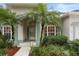 House entrance with palm trees and well-manicured landscaping at 4351 Hammersmith Dr, Clermont, FL 34711