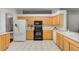 Kitchen with light wood cabinets, tile floors, and modern appliances at 4351 Hammersmith Dr, Clermont, FL 34711