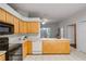 Kitchen with island, wood cabinets, and view to Gathering room at 4351 Hammersmith Dr, Clermont, FL 34711