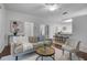 Bright living room features hardwood floors, a comfy sofa, and a view into the kitchen at 4351 Hammersmith Dr, Clermont, FL 34711