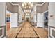 Long hallway featuring tile floors, decorative lighting, and access to various rooms at 504 Narrow View Ln, Groveland, FL 34736