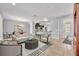 Open-concept living space with neutral tones and tile flooring leading into the kitchen and dining area at 504 Narrow View Ln, Groveland, FL 34736