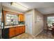 Kitchen with wood cabinets, tile flooring, and a window overlooking the backyard at 734 Boylston St, Leesburg, FL 34748