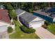 Aerial view showcasing the home's well-manicured lawn, landscaping, and two-car garage at 973 Belle Oak Dr, Leesburg, FL 34748