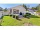 Well-maintained backyard featuring a brick patio, lush landscaping, and a privacy fence at 973 Belle Oak Dr, Leesburg, FL 34748