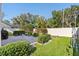 Well-maintained backyard featuring a brick patio, lush lawn, and trimmed hedges at 973 Belle Oak Dr, Leesburg, FL 34748