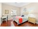 Bright bedroom features wood floors, a window view, and a desk providing a comfortable and functional space at 973 Belle Oak Dr, Leesburg, FL 34748