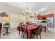 A well-lit dining area showcases a kitchen in the background, complemented by a chandelier and a checkered tablecloth at 973 Belle Oak Dr, Leesburg, FL 34748