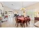 Bright dining room with a large chandelier, fireplace, and plenty of natural light at 973 Belle Oak Dr, Leesburg, FL 34748