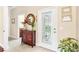 Inviting entryway featuring decorative mirror, cabinet, and stylish glass paneled front door at 973 Belle Oak Dr, Leesburg, FL 34748
