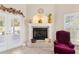 Cozy living area with a tiled fireplace, decorative mantle and hearth, and adjacent light-filled patio doors at 973 Belle Oak Dr, Leesburg, FL 34748