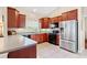 Updated kitchen features wood cabinets, stainless steel appliances, and tile floors at 973 Belle Oak Dr, Leesburg, FL 34748