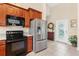 Well-appointed kitchen with stainless steel appliances, wooden cabinets, and tile flooring at 973 Belle Oak Dr, Leesburg, FL 34748