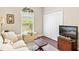 Bright sitting area with a large window, closet, and comfortable sofa at 973 Belle Oak Dr, Leesburg, FL 34748