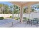 Enclosed patio with tiled floor, cozy seating and a view of the beautifully landscaped backyard at 973 Belle Oak Dr, Leesburg, FL 34748