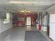 Well-organized garage with a workbench, storage cabinets, and epoxy flooring for a clean look at 2372 Arbordale Ave, The Villages, FL 32162