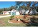 A cozy home's rear view features clean siding, well-kept lawn, and a blue garage door under a clear sky at 4800 Tara View Rd, Leesburg, FL 34748