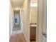 Hallway featuring carpeted floor and several doors to rooms and partial view into a bathroom at 8 Diamond Club Rd, Ocala, FL 34472