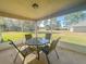 Screened-in lanai with a round table and chairs, perfect for outdoor relaxation at 8 Diamond Club Rd, Ocala, FL 34472