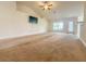 Spacious living room featuring a ceiling fan, large window, and neutral carpet at 8 Diamond Club Rd, Ocala, FL 34472