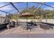 Relaxing screened patio with table, chairs, and umbrella at 917 Hawk Lndg, Fruitland Park, FL 34731